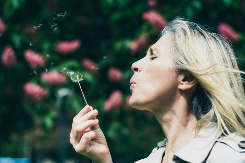 Terapias naturales en menopausia para sentirte mejor. Imagen mujer soplando una flor.