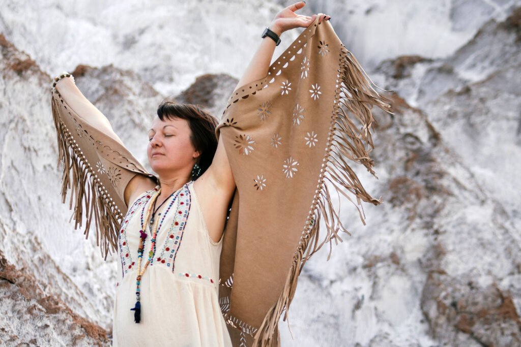 Chamanismo y Menopausia. Mujer con los brazos abiertos en conexión con la naturaleza.