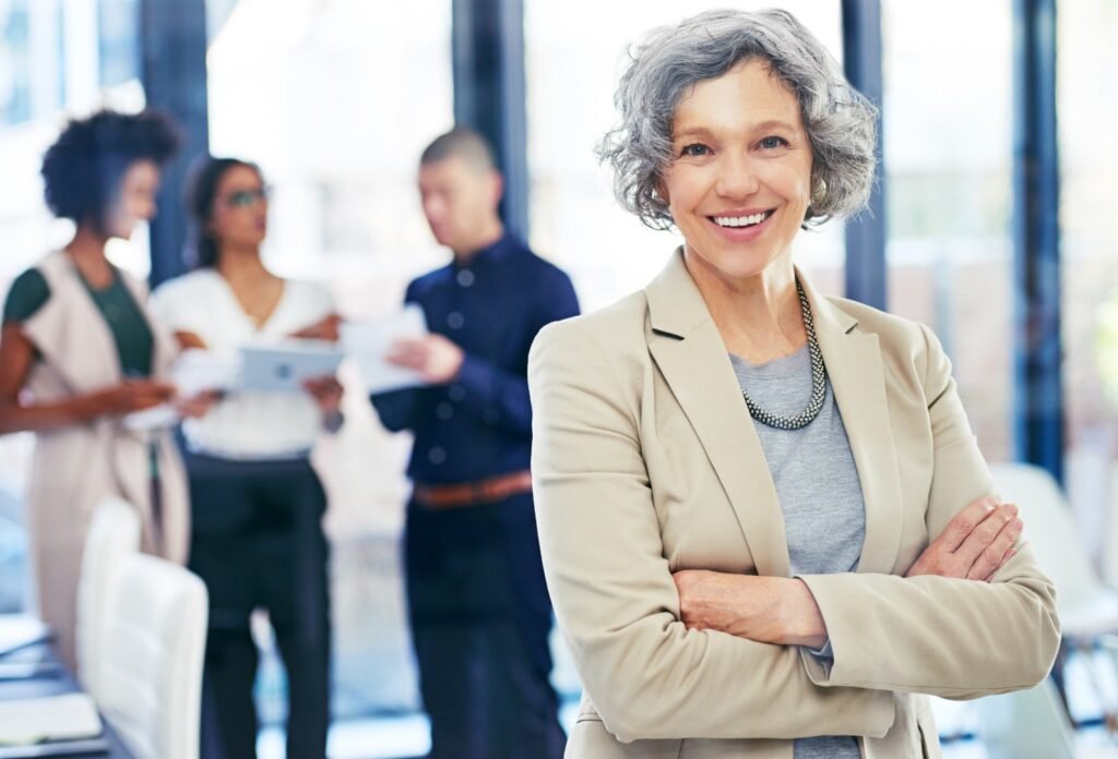 Liderazgo femenino en la menopausia - Almas Divinas. Mujer empoderada de brazos cruzados sonriendo