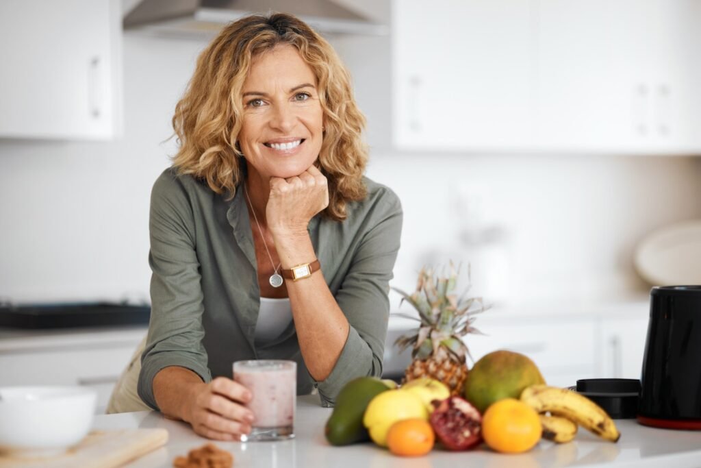 Desintoxicación en la menopausia - Imagen destacada - Almas Divinas. Una mujer a punto de tomar un vaso de batido