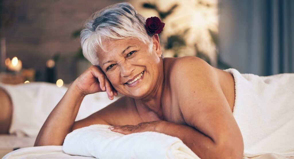 Mujer madura feliz sonriendo en un momento de relajación íntima y autoexploración