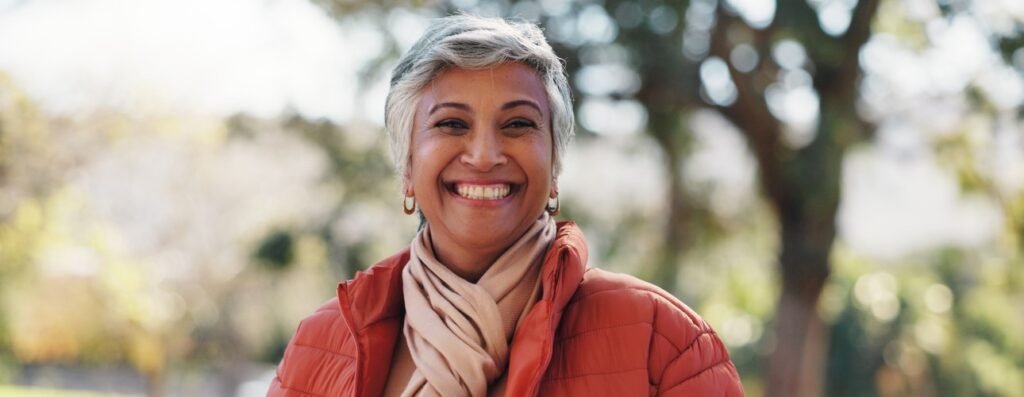 Mujer sonriente al aire libre cultivando la alegría en la menopausia
